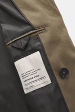 Close-up interior view of Belstaff Trenchcoat 'Supersenia' gray-brown showing cotton twill fabric, button, and label details.

Description: <p>In the trendy army style: This noble trench coat by BELSTAFF is part of the 'Phoenix' collection and was typical