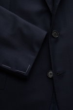 Close-up front view of the Cesare Attolini Anzug dark navy jacket sleeve and buttons, made from smooth Super 150'S wool with slim fit tailoring.