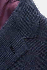 Close-up front view of the Stile Latino Anzug 'Vincenzo' navy/graublau kariert jacket lapel showing the timeless Prince-of-Wales pattern, soft wool-linen blend fabric, and red striped inner lining, highlighting exquisite Italian craftsmanship and slim fit