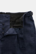 Close-up front view of the open button-fly waistband with retro side-adjuster of the Stile Latino Anzug 'Vincenzo' navy/graublau kariert trousers, showcasing the Prince-of-Wales wool-linen blend fabric and fine Italian craftsmanship. The two-piece suit fe