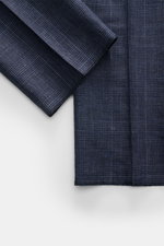 Close-up front view of the sleeve and lower front panel of the Stile Latino Anzug 'Vincenzo' navy/graublau kariert suit, featuring a timeless Prince-of-Wales pattern in soft wool-linen blend fabric with retro side-adjusters and button-fly. Der Zweiteiler 
