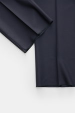 Navy fabric detail of Cesare Attolini Suit navy shown from above, highlighting pure Super 150'S wool knit, smooth texture, and slim fit cut.