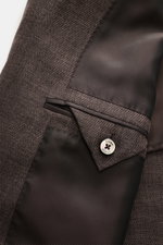Nahaufnahme vom Innenfutter und Knopf des Zegna Anzugs 'Natural' dunkelbraun meliert, Details der Verarbeitung sichtbar.