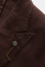 Close-up front view of the Santaniello Anzug braun lapel, showing its soft, pure linen fabric, two-button style, and logo button with chain.