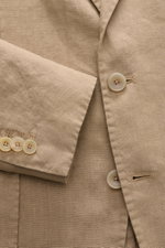 Nahaufnahme des Santaniello Anzugs taupe aus reinem Leinen, Fokus auf Knöpfe und Ärmel, zeigt weichen Griff und Vintage-Optik.