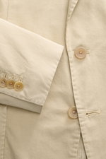 Close-up top-down view of the Santaniello Anzug sand jacket sleeve and front button area, showcasing fine cotton twill fabric and buttons. Lässige Eleganz mit Stil: Dieser Anzug von SANTANIELLO überzeugt mit feinstem Baumwoll-Twill und modernem Design - i