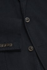 Nahaufnahme aus schräger Perspektive des Boglioli Cordanzugs 'K. Jacket' navy mit tailliertem Sakko aus elastischem Cord-Baumwoll-Mix, sichtbaren Knöpfen und aufgesetzter Hüfttasche.