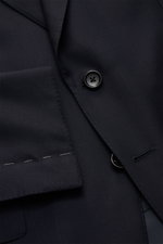 Close-up image showing the button and lapel details of the Tom Ford Anzug 'Shelton' navy suit, photographed from above. An Klasse und Zeitlosigkeit kaum zu übertreffen ist der luxuriöse TOM FORD Anzug 'Shelton' aus reiner, fein gewebter Wolle mit schmaler