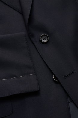 Close-up image showing the button and lapel details of the Tom Ford Anzug 'Shelton' navy suit, photographed from above. An Klasse und Zeitlosigkeit kaum zu übertreffen ist der luxuriöse TOM FORD Anzug 'Shelton' aus reiner, fein gewebter Wolle mit schmaler
