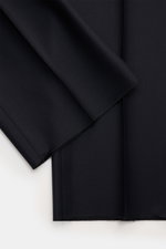 Close-up fabric detail of the Tom Ford Anzug 'Shelton' navy suit showing fine woven pure wool with smooth, soft texture, photographed flat from above. An Klasse und Zeitlosigkeit kaum zu übertreffen ist der luxuriöse TOM FORD Anzug 'Shelton' aus reiner, f