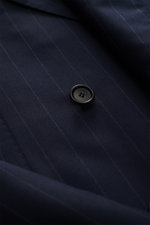 Close-up from above of the Cesare Attolini Anzug anthrazit gestreift sleeve showing fine pinstripes and a black button on pure 160'S wool fabric with a very soft touch.