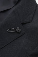 Close-up front view of Lardini Suit dark navy melange lapel made from pure new wool with subtle check pattern and black flower pin.