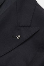 Close-up front view of the Tagliatore Suit 'Vesuvio' dark navy lapel showing a silver pin on the double-breasted virgin wool and cashmere blend fabric.