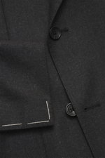 Close-up view of the Tagliatore Suit 'Vesuvio' anthracite melange showing the double-breasted three-button jacket with notched lapel, classic breast pocket, patch hip pockets, unfinished sleeve cuffs, and fine stitching detail, photographed from the front