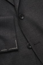 Close-up front view of Tagliatore Suit 'Vesuvio' dark grey melange showing tailored two-button jacket in soft Super 120's virgin wool with notched lapel, classic breast pocket, and unfinished sleeve cuffs.