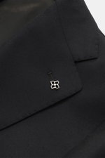Close-up from above of the black Tagliatore Suit 'Vesuvio' lapel featuring a silver pin, made from pure Super 120's virgin wool with a soft touch and slim fit.