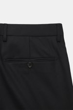 Close-up rear view of the trousers from the Tagliatore Suit 'Vesuvio' black, showcasing the pure Super 120's virgin wool fabric, soft touch, and slim fit design. The tailored two-piece suit features a two-button jacket with notched lapel, classic breast p