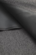Grey melange fabric detail of Tagliatore Suit 'Vesuvio' with folded lining, photographed close-up from above to show texture and stitching.