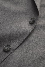 Grey melange fabric close-up of Tagliatore Suit 'Vesuvio' showing Super 110's virgin wool with slight stretch and buttons, photographed from above.