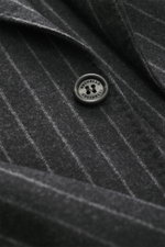 Nahaufnahme des dunkelgrau/hellgrau gestreiften Brunello Cucinelli Anzugs, Fokus auf Knopf mit Logo, feine Schurwoll-Cashmere-Qualität.