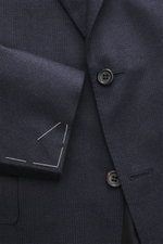 Nahaufnahme des Canali Anzugs navy kariert, fotografiert aus frontaler Perspektive, reine Wolle, weicher Griff, Glencheck-Muster, Slim Fit Sakko mit fallendem Revers, tailliert, Zwei-Knopf-Stil, Brusttasche, Hüfttaschen mit Patte, unfertige Ärmelabschlüss