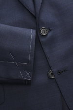 Close-up front view of Brioni Suit 'Brunico' navy melange jacket showing two-button style, notched lapel, and smooth pure wool fabric.