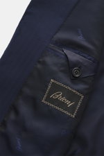 Close-up interior view of the Brioni Suit 'Brunico' navy jacket showing branded lining, button, and label, crafted from a soft wool-silk blend.