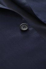 Close-up, angled view of Brioni Suit 'Brunico' navy fabric and button, showcasing its silk-wool blend, soft touch, and tailored details.
