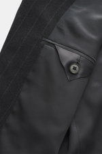 Close-up inside view of the Zegna Suit dark grey striped showing elastic wool fabric, slim fit, and tailored jacket details with button.