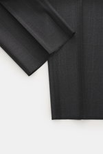 Close-up top-down view of Zegna Anzug 'Milano Trofeo' schwarz fabric, showcasing its soft pure wool texture and subtle check pattern.