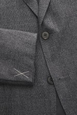 Close-up front view of the Zegna Suit grey melange jacket showing pure wool fabric with soft touch, slim fit, two-button style, notched lapel, and woven texture.