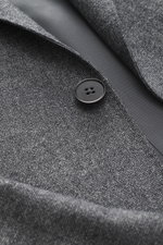 Close-up front view of Zegna Suit grey melange showcasing pure wool fabric with soft touch, distinctive woven texture, and black button detail.