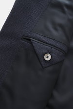 Close-up of the Zegna Suit 'Trofeo' navy melange sleeve and interior lining from a top-down perspective, showing the pure wool fabric with a subtle check pattern and a Zegna-branded button.