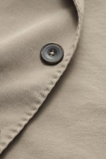 Nahaufnahme des Santaniello Anzugs taupe aus Baumwoll-Twill mit Knopf, weichem Griff und leichter Elastizität, Detailansicht Stoff und Naht.