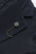 Alt-Tag (124 Zeichen): Nahaufnahme des fallenden Revers am Santaniello Anzug navy aus Baumwoll-Twill mit Kissing Button und Ketten-Detail.