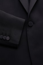 Close-up front view of the Tagliatore Tuxedo 'Napoli' dark navy jacket sleeve and button, showcasing pure Super 110'S virgin wool fabric.