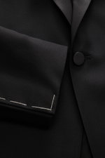 Close-up front view of Tagliatore Tuxedo black lapel and button in pure Super 110'S virgin wool with smooth feel, slim fit.