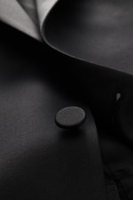 Close-up front detail of the Tagliatore Tuxedo black button and lapel, photographed from a slightly angled top view, showcasing the pure Super 110'S virgin wool fabric with a smooth feel and slim fit.