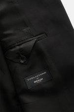 Close-up inside view of Tagliatore Tuxedo black showing smooth black satin lining, interior button, and brand label stitched on fabric.