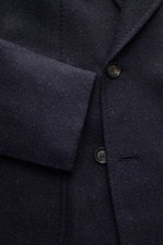Nahaufnahme des Stile Latino Sakko 'Andrea' dark navy von vorne schräg oben, zeigt Panama-Stoff aus Wolle, Alpaka und Seide, Zweireiher mit Spitzrevers, weicher Griff, Slim Fit, drei Knöpfe, klassische Brusttasche, aufgesetzte Hüfttaschen, unfertige Ärmel