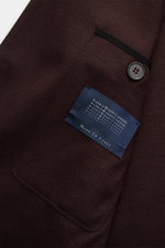 Close-up of the inside pocket and label of Harris Wharf London Jersey-Sakko dunkelbraun, showing dark brown wool jersey fabric, button, and stitching from a top-down perspective.

Description: <p>Die elegante Optik eines Sakkos trift auf den Komfort einer