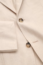 Nahaufnahme von Sipario Sakko 'Ginza' sand gemustert aus Leinen-Baumwoll-Mix, tonaler Fischgrat, Slim Fit, tailliert, Drei-Knopf-Stil, fallendes Revers, Brust- und Hüfttaschen, halbfutter, unfertige Ärmelabschlüsse, rückwärtige Seitenschlitze.