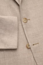 Tagliatore Sakko 'Monte Carlo' beige meliert, Nahaufnahme von Vorderseite mit Fischgrat-Struktur, zwei Knöpfen, fallendem Revers und Manschette.