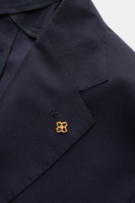 Tagliatore Sakko 'Monte Carlo' navy in Nahaufnahme von schräg oben, feiner Schurwoll-Seiden-Mix, fallendes Revers mit goldfarbenem Markentyp-Pin.