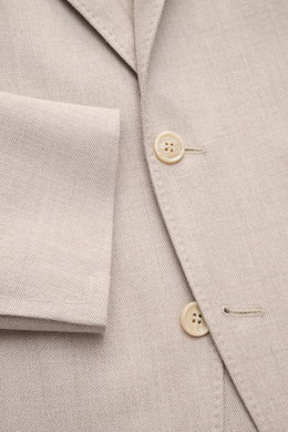 Brunello Cucinelli Sakko sand meliert, Nahaufnahme von Knöpfen, fallendem Revers, tailliertem Drei-Knopf-Stil, weichem Cashmere-Seide-Mix, markanter Webstruktur.