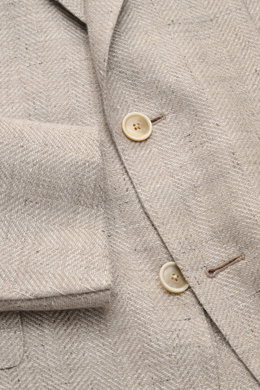 Nahaufnahme aus schräger Perspektive des Caruso Sakkos 'Aida' beige meliert mit Fischgratstruktur, Leinen-Woll-Mix, Slim Fit, Zwei-Knopf-Stil und halbfertigen Ärmeln.