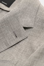 Nahaufnahme des Zegna Sakko 'Riviera' grau/weiß meliert von oben, zeigt feine Webstruktur, weichen Griff, fallendes Revers und Brusttasche.