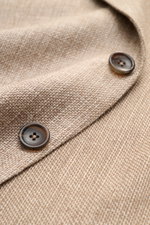 Nahaufnahme des taupe melierten Zegna Sakkos mit feinem Strukturgewebe, zwei Knöpfen und weichem Griff aus Leinen, Wolle und Seide.