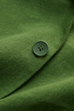 Nahaufnahme des grünen Percival Sakko 'Tailored Linen' mit Knopf aus Leinen-Baumwoll-Mix, leichte Struktur sichtbar, Detail von fallendem Revers.