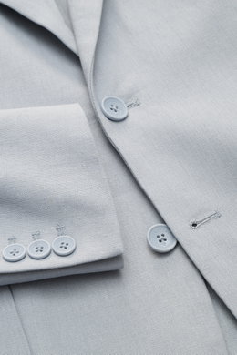 Nahaufnahme des Percival Sakkos 'Tailored Linen' rauchblau aus atmungsaktivem Leinen-Baumwoll-Mix, zeigt Knöpfe, Ärmel mit Knopfleiste und fallendes Revers, fotografiert von oben.